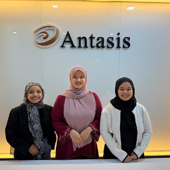 Antasis team members in front of the Antasis office branding